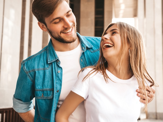 Portrait of smiling beautiful girl and her handsome boyfriend. Woman in casual summer jeans clothes. Happy cheerful family. Female having fun and looking at each other