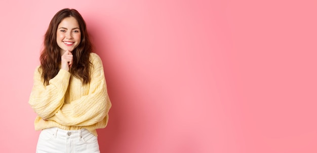 Free photo portrait of smiling beautiful lady looking determined touching chin and staring satisfied seeing som