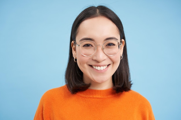 Free photo portrait of smiling beautiful woman in glasses testing her eyesight wearing new spectacles standing