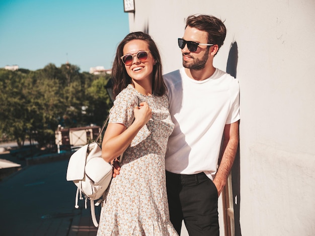 Portrait of smiling beautiful woman and her handsome boyfriend Woman in casual summer clothes Happy cheerful family Female having fun Couple posing on the street background in sunglasses