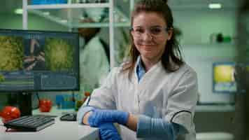 Foto gratuita ritratto di donna biologa sorridente che analizza un organismo geneticamente modificato