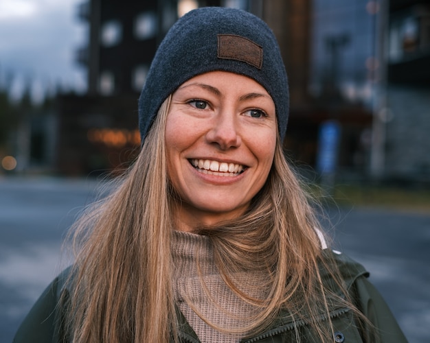 Foto gratuita ritratto di una donna caucasica bionda sorridente in cappotto e cappello in inverno