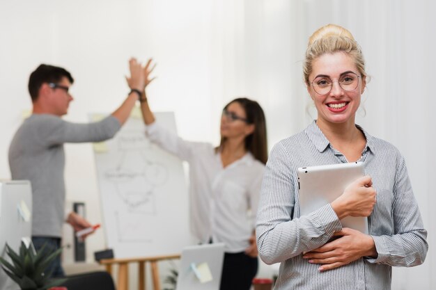 Portrait of smiling blonde woman holding a laptop