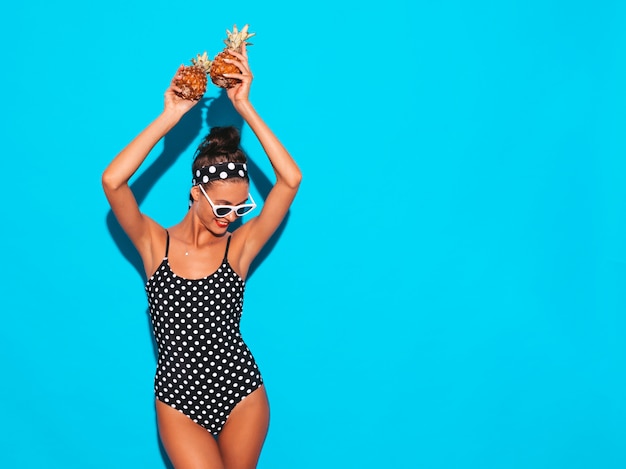 여름 완두콩 수영복 수영복과 선글라스에 웃는 갈색 머리 여자의 초상화.