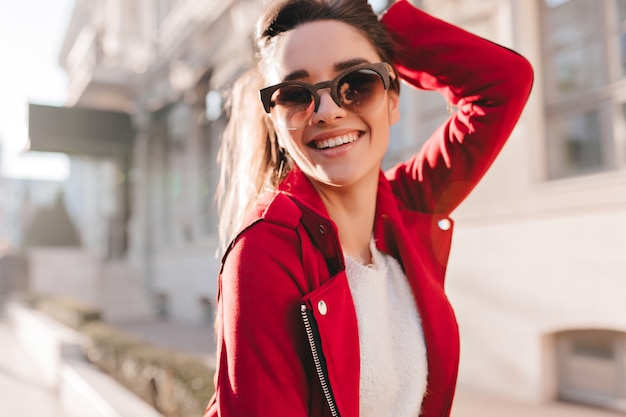 Portrait of smiling brunette woman enjoying sunny day outdoor