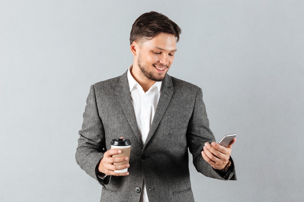 Portrait of a smiling businessman looking at mobile phone