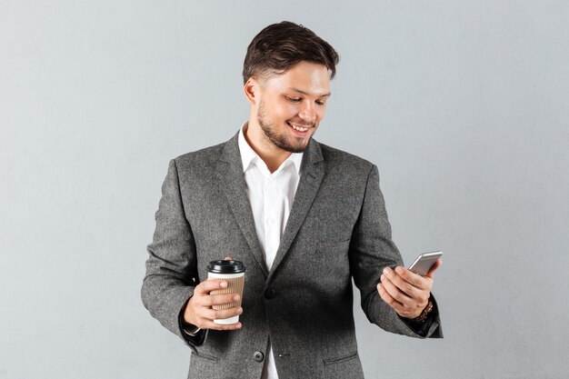 Портрет улыбающегося бизнесмена, глядя на мобильный телефон