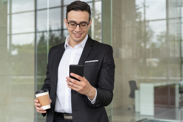 Ritratto dell'uomo d'affari sorridente con il messaggio della lettura del caffè