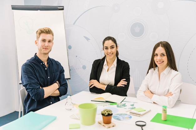 Portrait of smiling businesspeople with folded hands