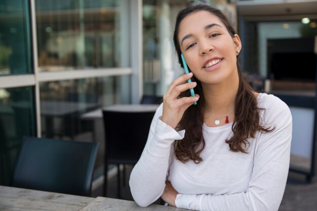 Portrait of smiling businesswoman talking on phone at cafe