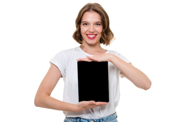 Free photo portrait of a smiling cheerful girl showing blank screen tablet