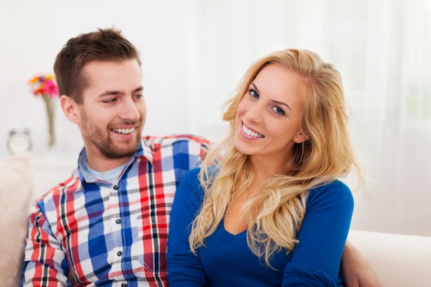 Free photo portrait of smiling couple in living room