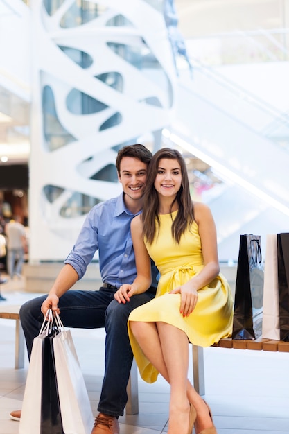 Foto gratuita ritratto di coppia sorridente nel centro commerciale