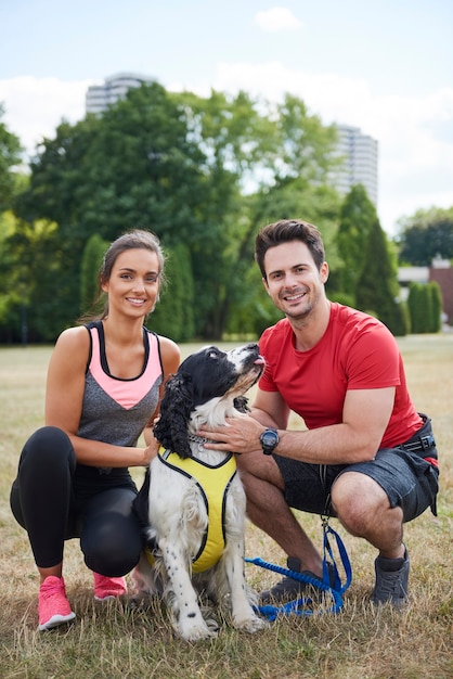 Free photo portrait of smiling couple and their dog after workout