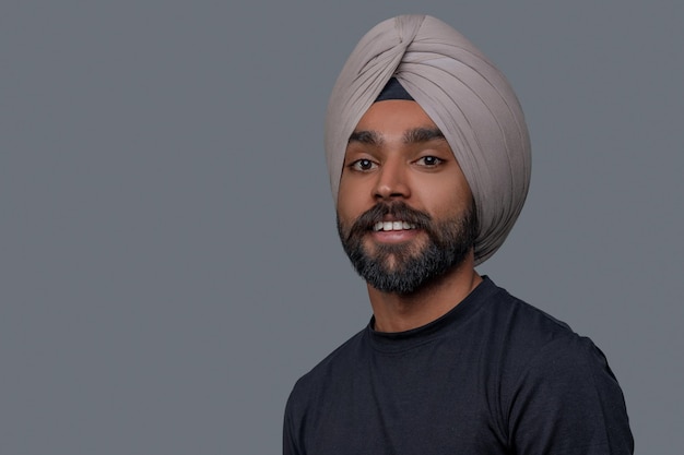 Portrait of a smiling cute middle-aged guy posing for the camera against the gray background