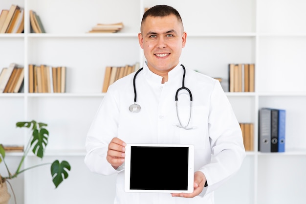 Free photo portrait of smiling doctor holding photo mock up