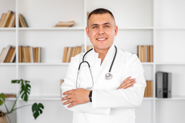 Free photo portrait of smiling doctor with cross hands