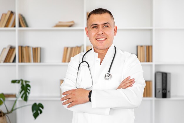 Portrait of smiling doctor with cross hands