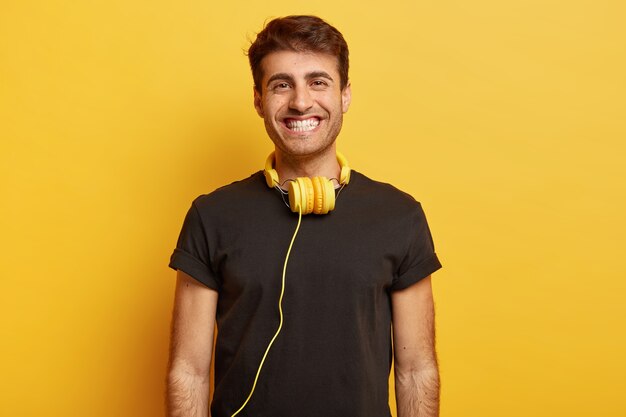 Portrait of smiling European guy with toothy smile, white teeth, enjoys spare time