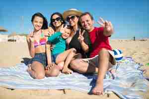 Foto gratuita ritratto di famiglia sorridente in spiaggia