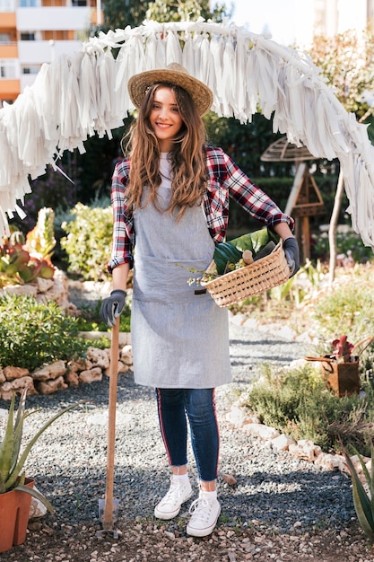 Portrait of a smiling female gardener in grey apron looking at camera