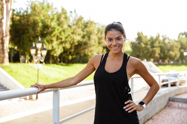 Portrait of a smiling fitness woman in earphones