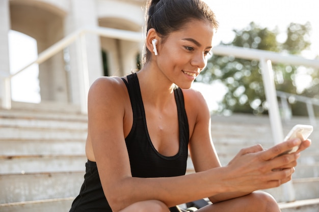Portrait of a smiling fitness woman in earphones