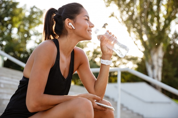 Portrait of a smiling fitness woman in earphones