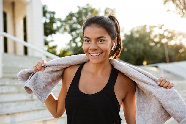 Портрет улыбающегося фитнес женщина с полотенцем отдыха