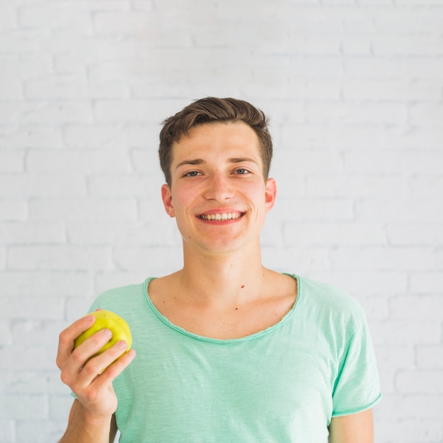 Free photo portrait of smiling girl holding fresh apple fruit