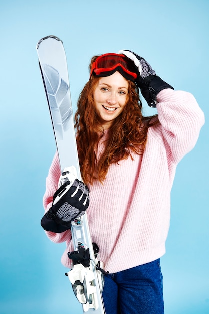 彼女のスキーを保持している笑顔の女の子の肖像画