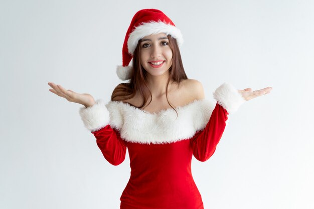 Портрет улыбающейся девушки в платье Санта, пожав плечами