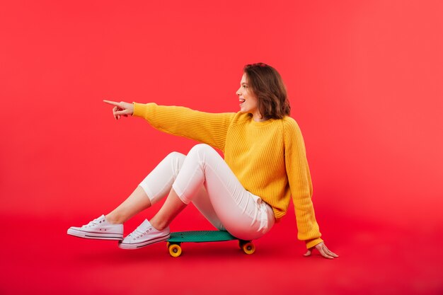 Portrait of a smiling girl sitting on a skateboard