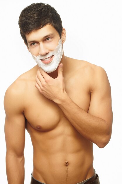 Portrait of smiling handsome man shaving