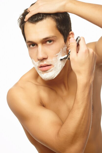 Portrait of smiling handsome successful man shaving