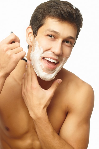 Portrait of smiling handsome successful man shaving