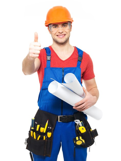 Portrait of smiling handyman with tools and paper showing thumbs up sign   isolated on  white background