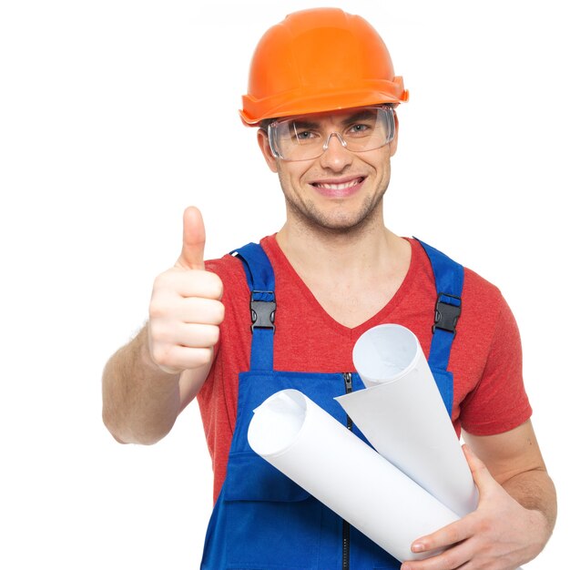 Portrait of smiling handyman with tools and paper showing thumbs up sign isolated on white