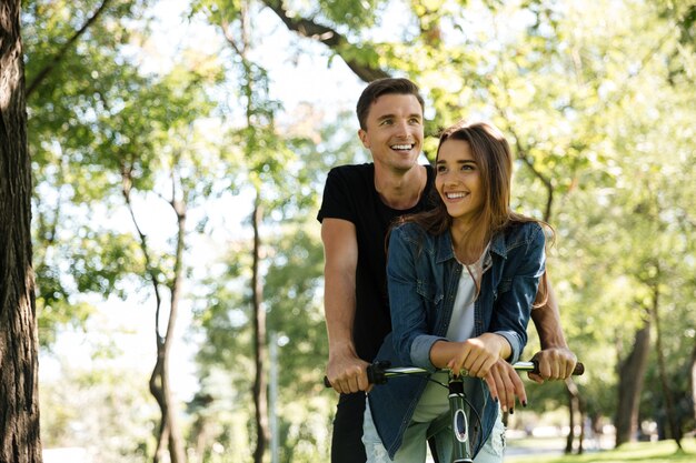 自転車に乗って笑顔の幸せなカップルの肖像画