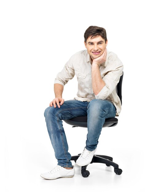 笑顔の幸せな男の肖像画は、白で隔離のオフィスの椅子に座っています。