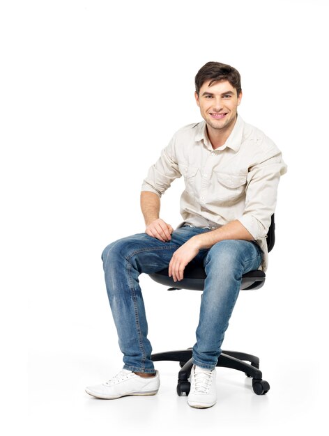 笑顔の幸せな男の肖像画は、白で隔離のオフィスの椅子に座っています。