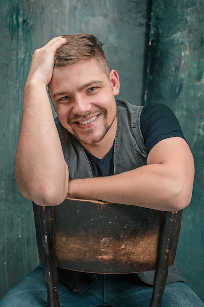 Free photo portrait of smiling happy man sitting on the chair