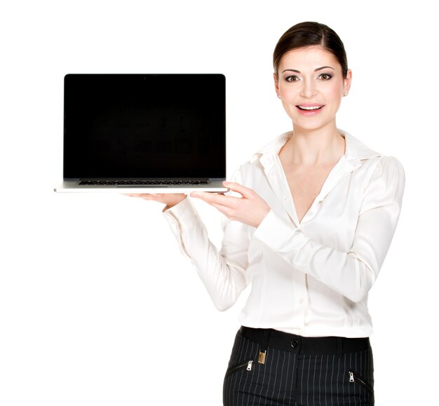 Portrait of smiling happy woman holds laptop on palm with blank screen - isolated on white. Concept communication.
