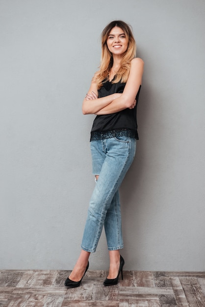 Free photo portrait of a smiling happy woman standing with arms folded