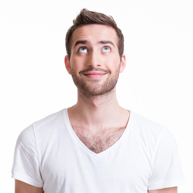 Portrait of smiling happy young man looking up - isolated on white