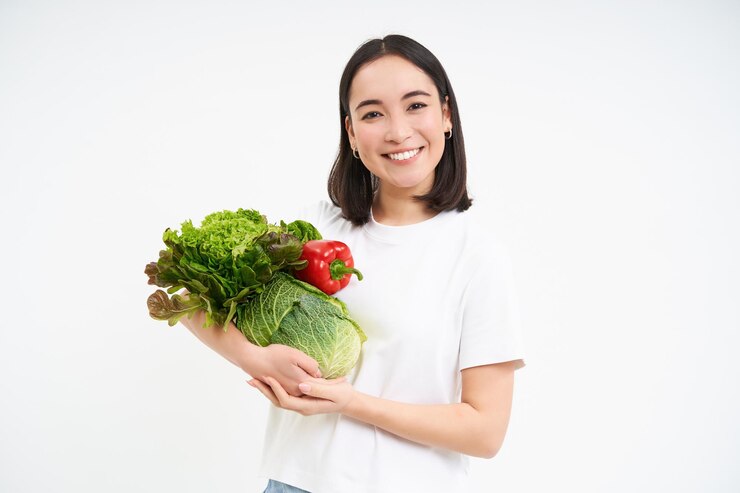 무료 Photo 웃고 있는 건강한 여성 채식주의자의 초상화는 녹색 유기농 채소를 보여주고 행복한 격리를 찾고 있습니다.