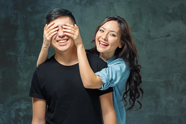 Portrait of smiling Korean couple on a gray studio