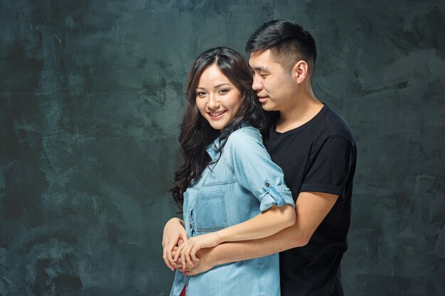 Portrait of smiling Korean couple on a gray studio