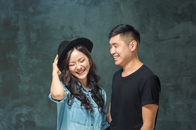 Portrait of smiling Korean couple on a gray studio
