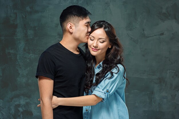 Portrait of smiling Korean couple on a gray